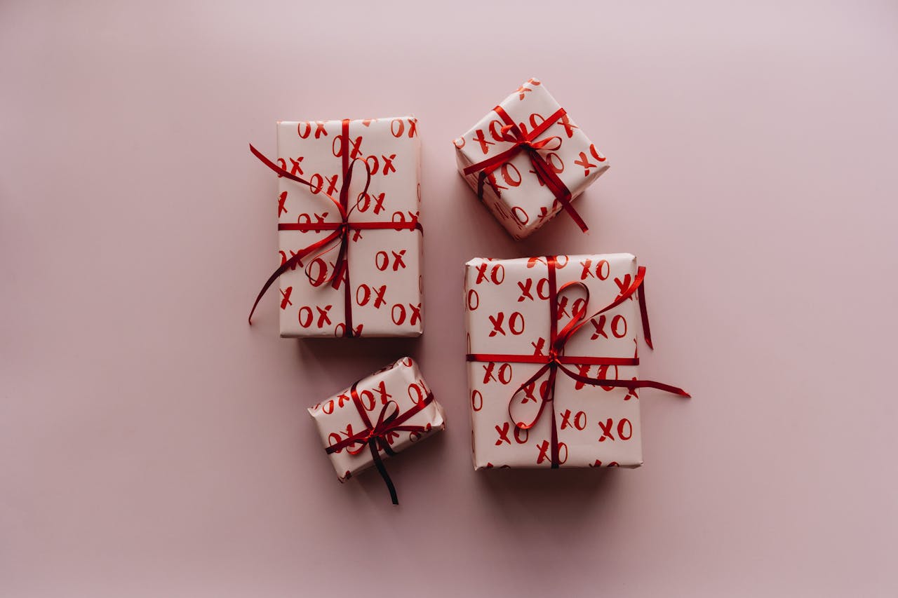 A collection of beautifully wrapped gifts with red bows and XO pattern, perfect for celebrations.